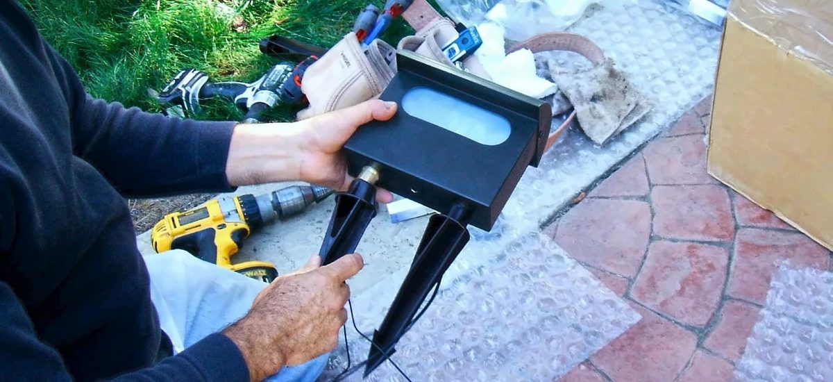 A light fixture being fitted to its ground stakes