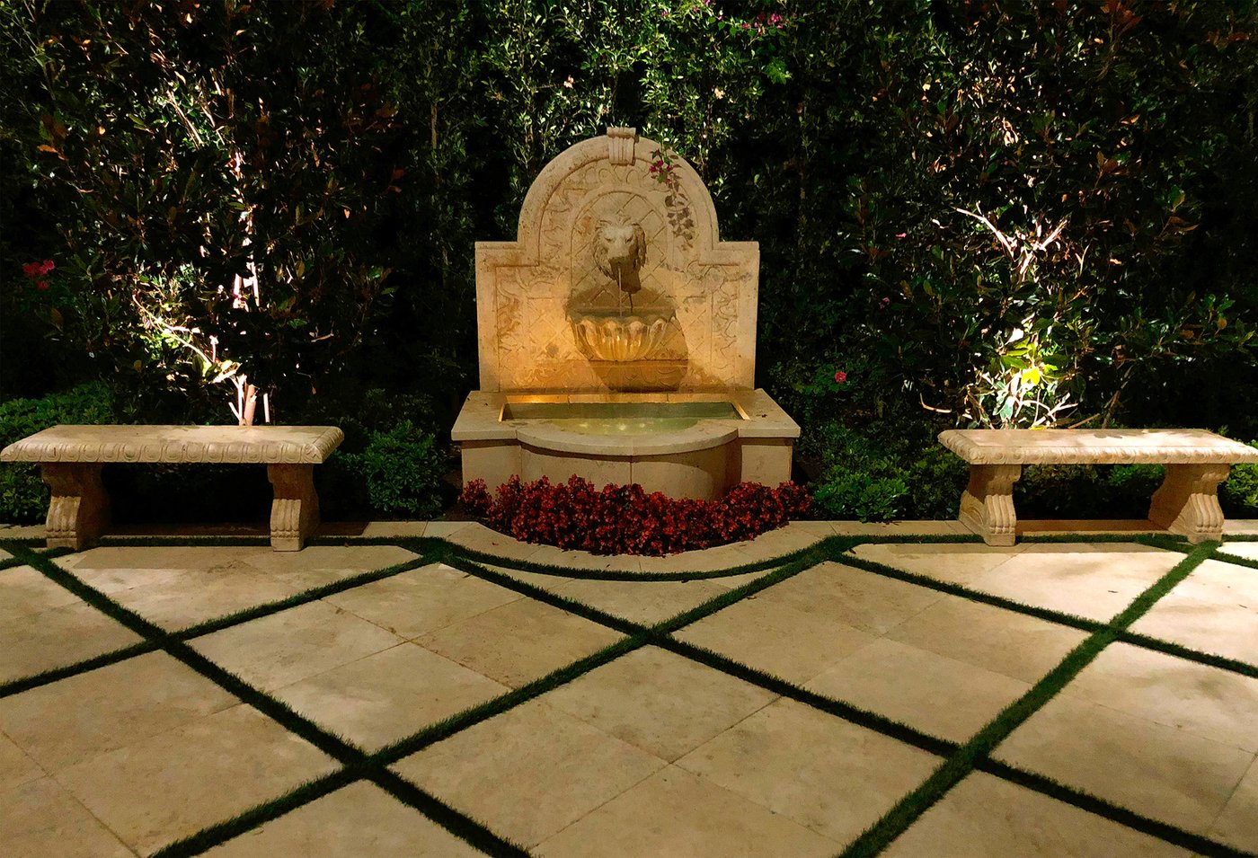 Stone wall fountain lit at night