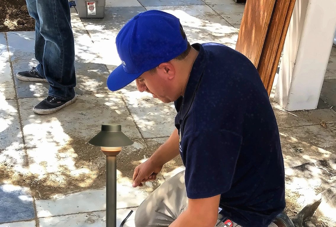 A technician connecting a path light on site